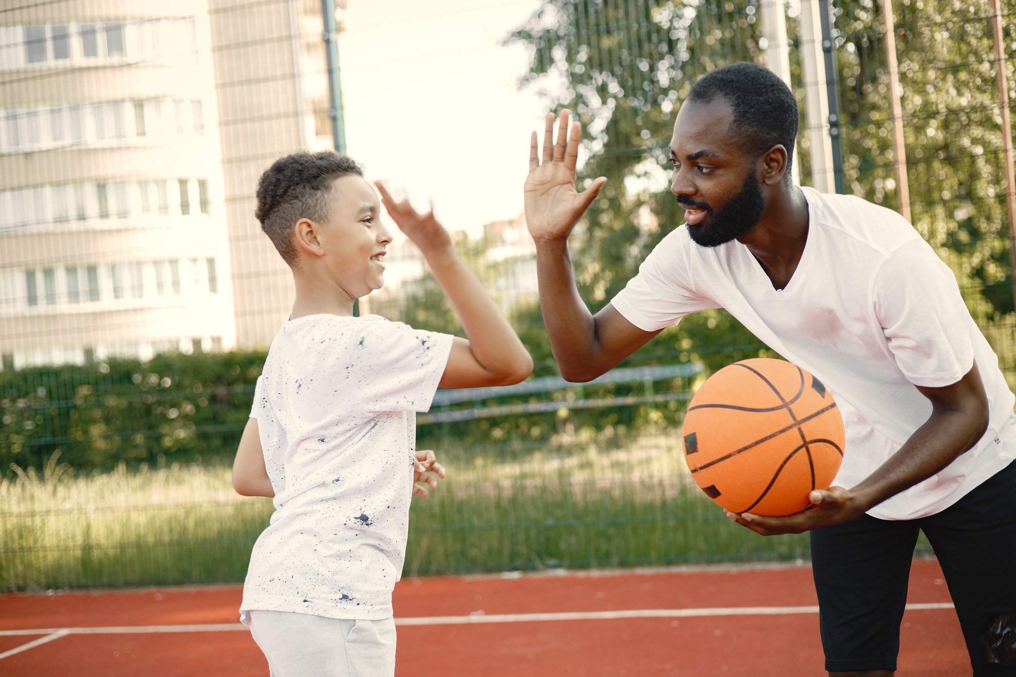 Father High-fiving Son during Basketball Game 